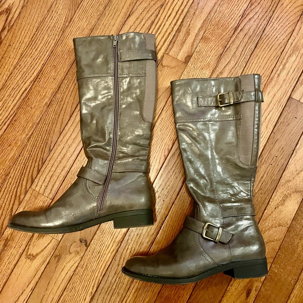 Riding boot with a buckle strap detail and zipper closure.
9.5 Grey.